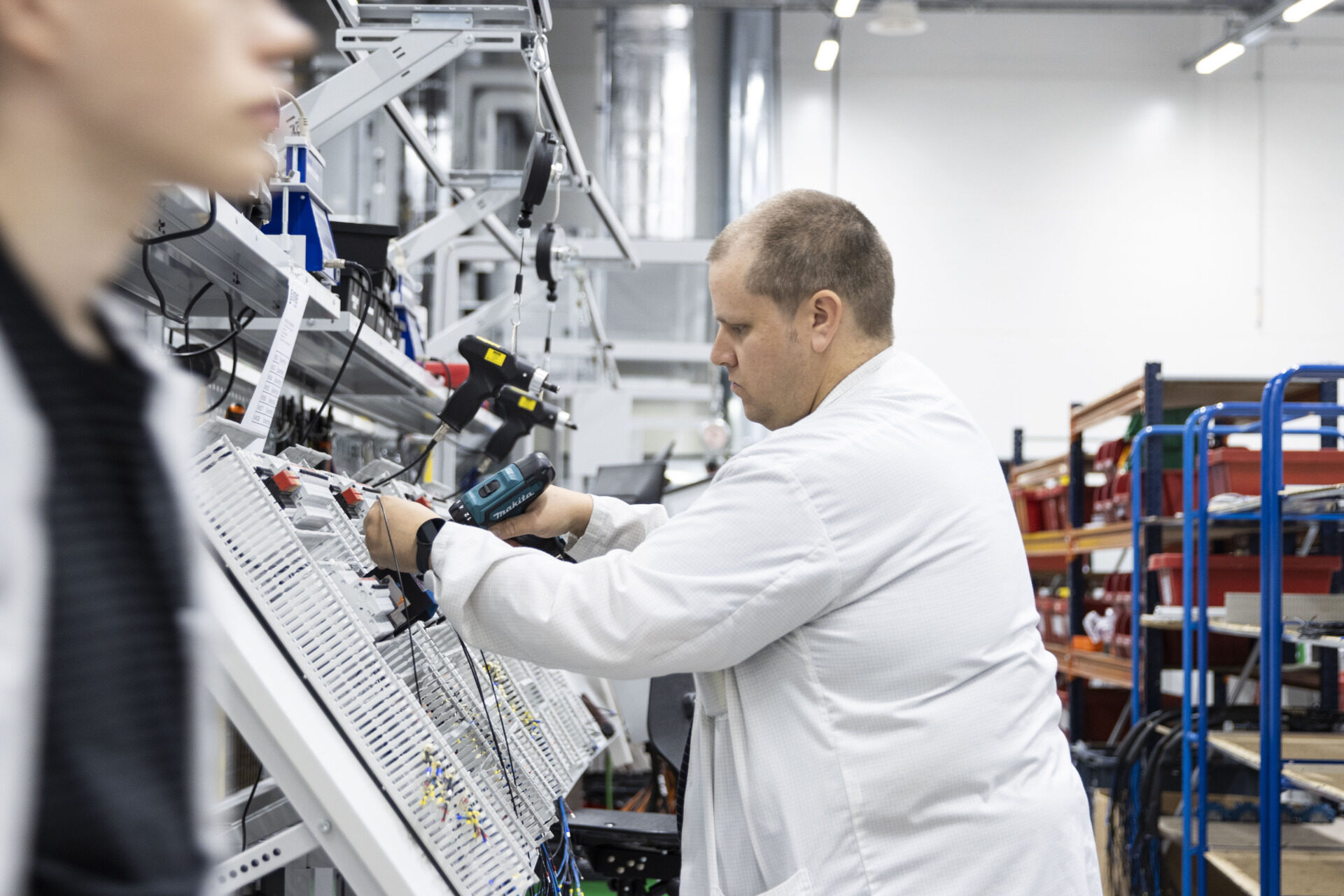 A person assembling an electrical system in a factory