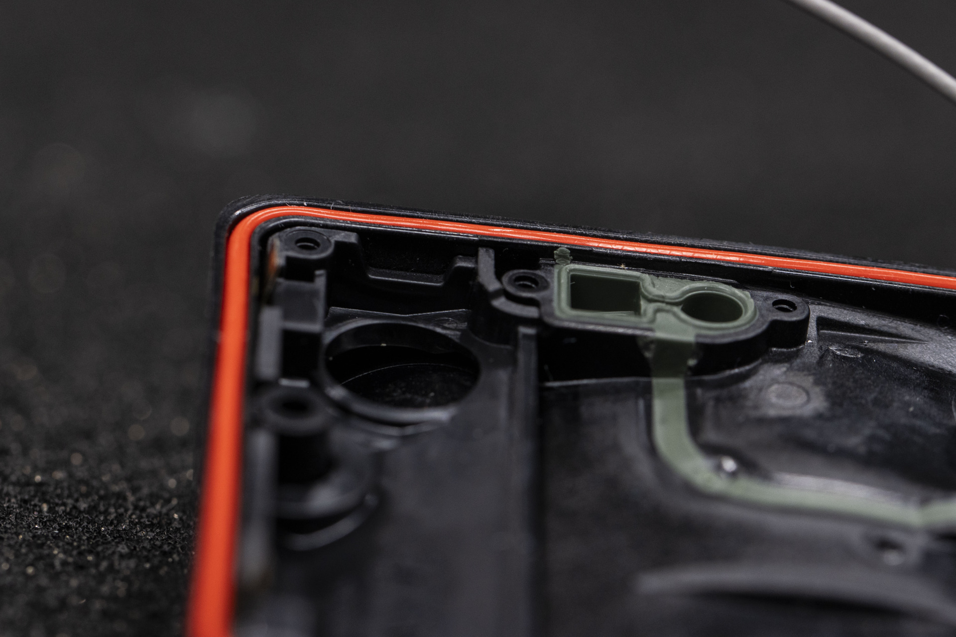 A plastic electronics enclosure with a red sealing